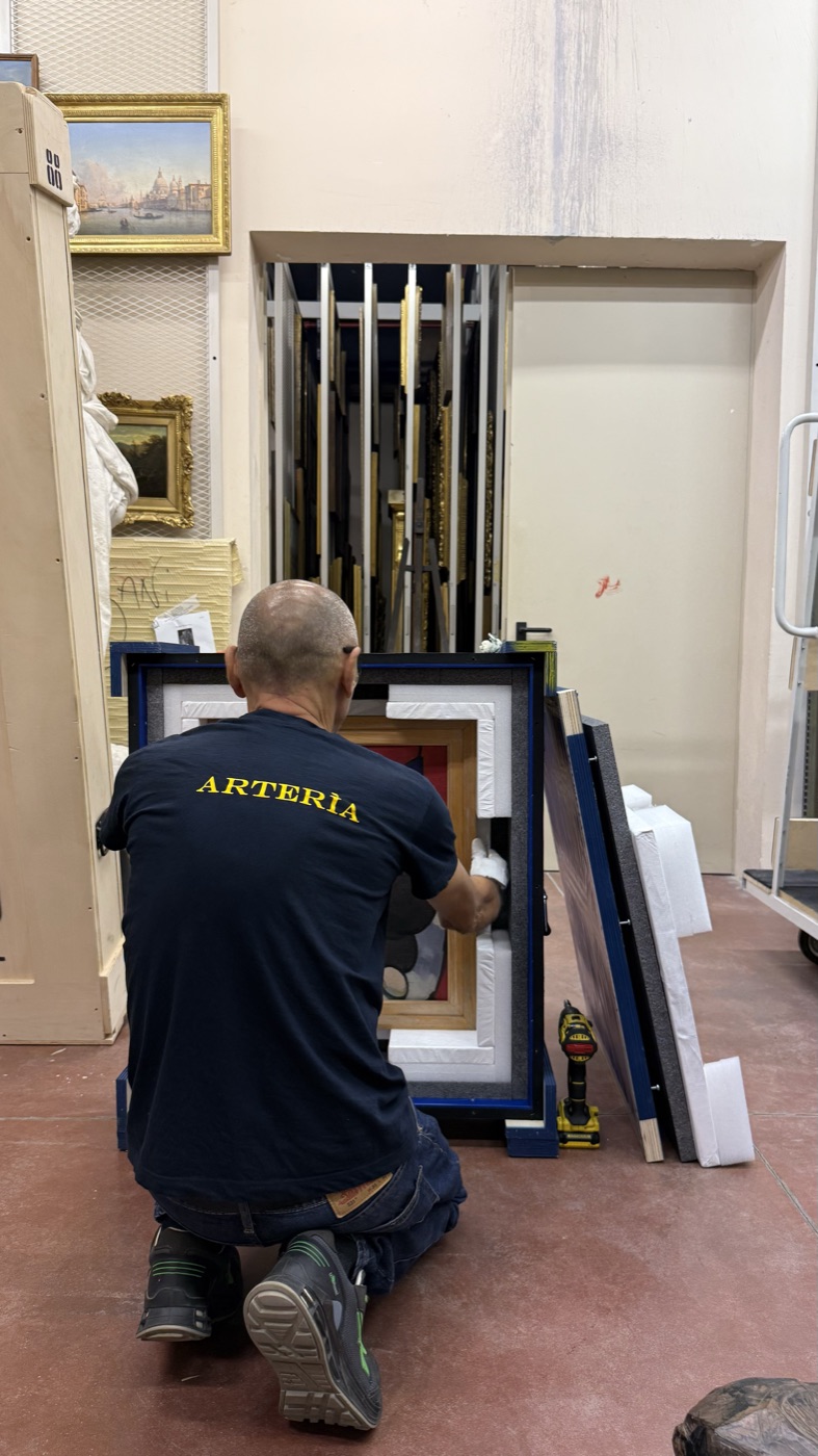 art handler preparing framed works at GAM